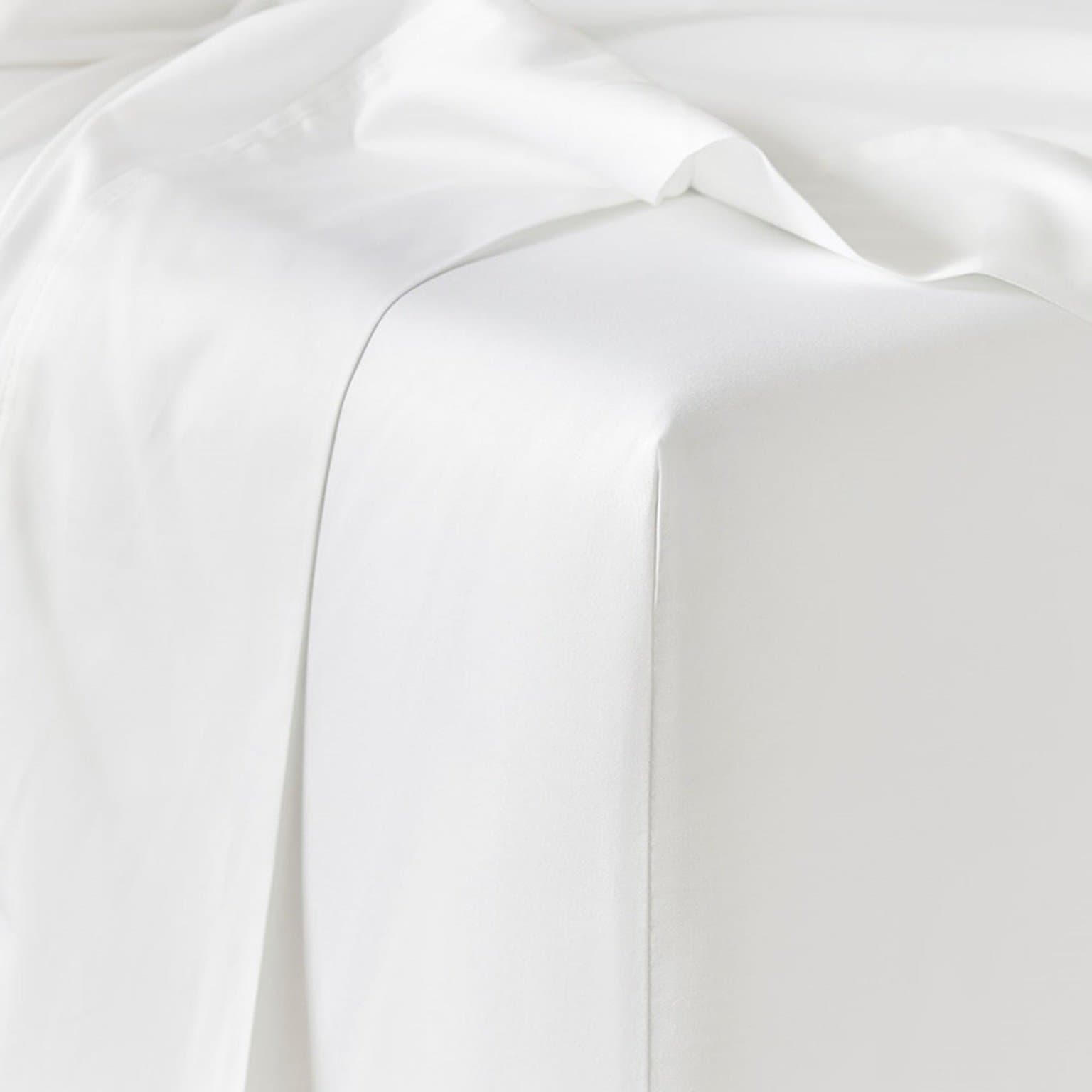 White fitted and flat sheets on a bed, from the C4G linen range supplied from Germiston, Johannesburg